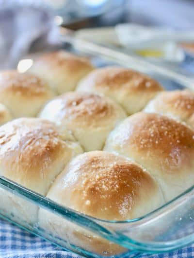 homemade rolls in a glass pan on a checkered cloth