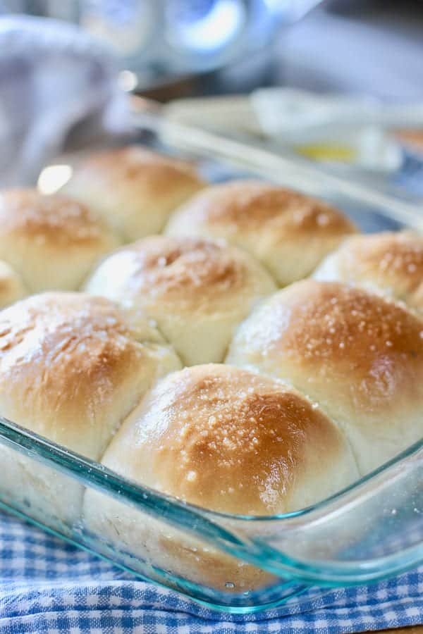 homemade rolls in a glass pan on a checkered cloth