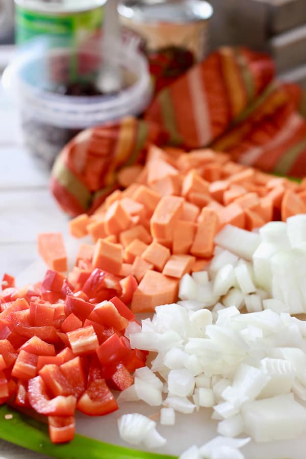 onions, peppers and potatoes on a cutting board