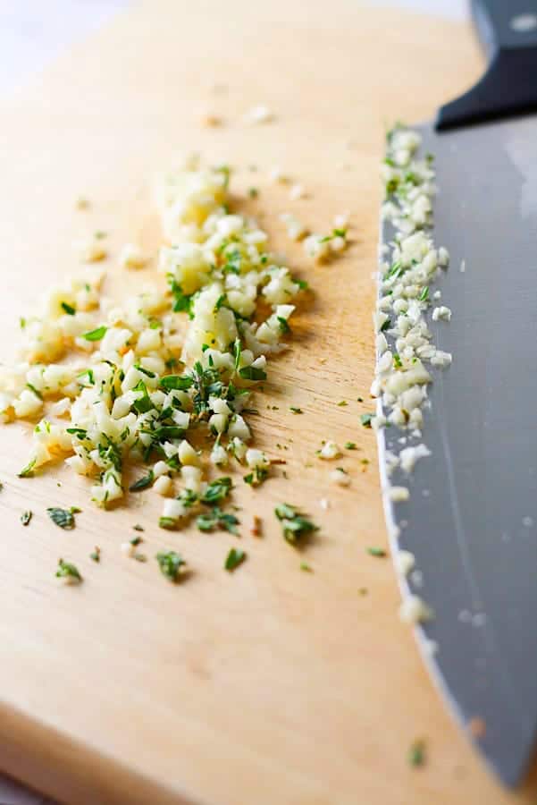 chopped garlic and thyme on a cutting board