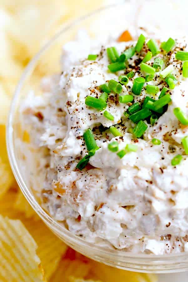 up close French onion dip garnished with chives and salt and pepper