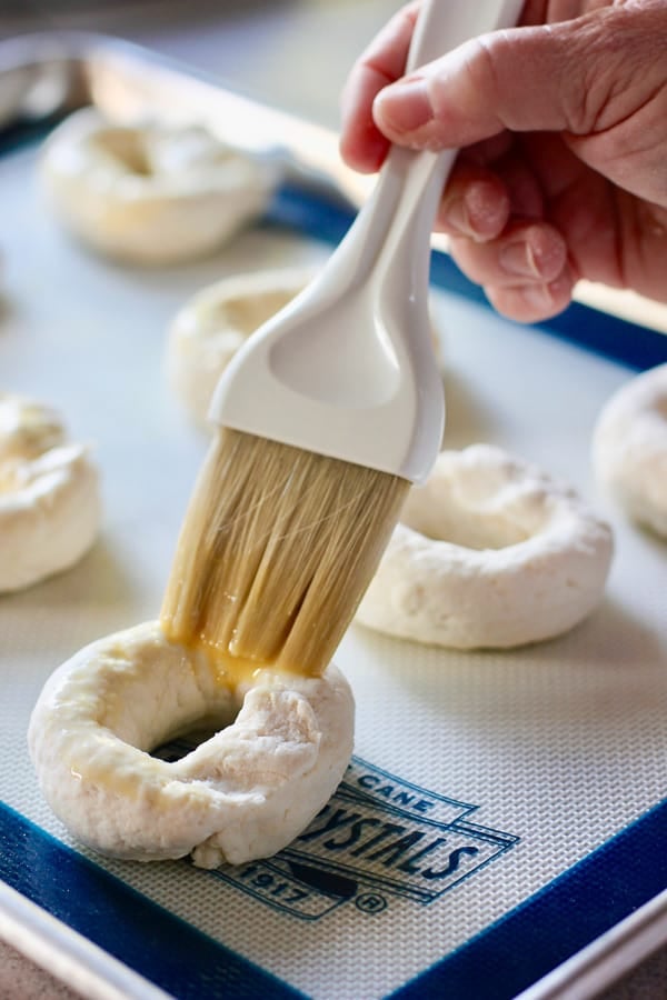 brushing egg onto bagel dough