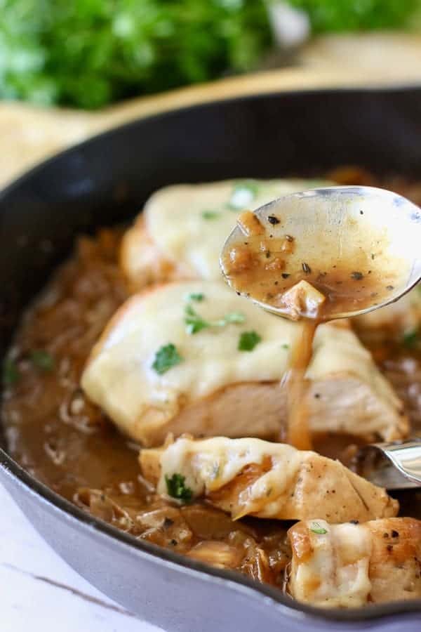 French onion chicken with sauce being poured over it