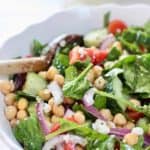 chickpeas, spinach salad in a white bowl