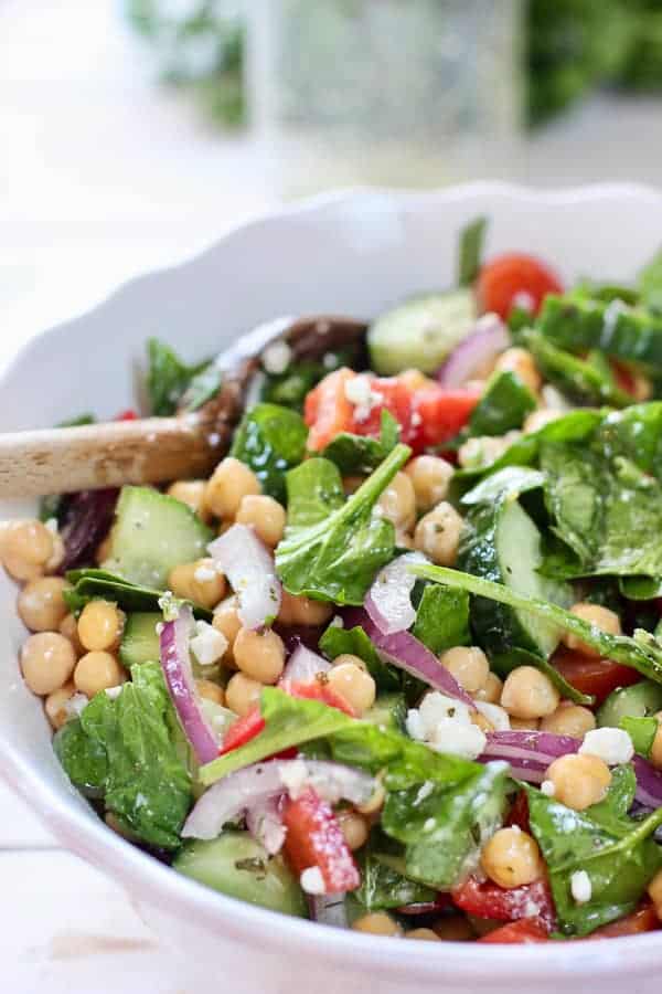 chickpeas, spinach salad in a white bowl