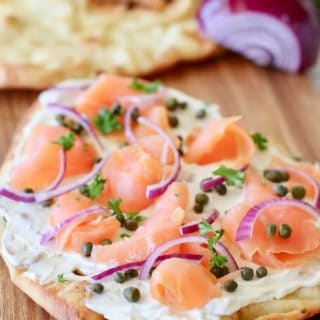 smoked salmon pizza on a board ready to serve