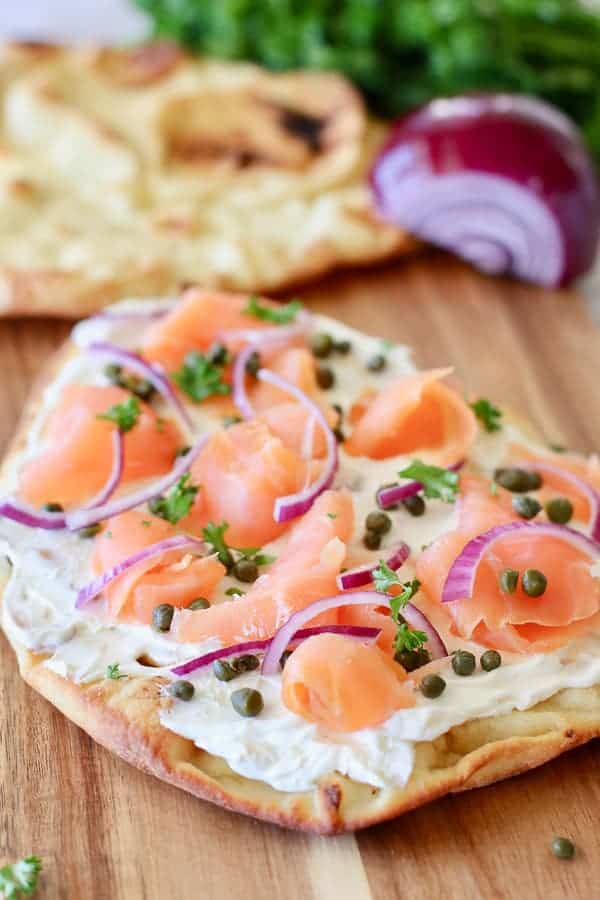 smoked salmon pizza on a board ready to serve