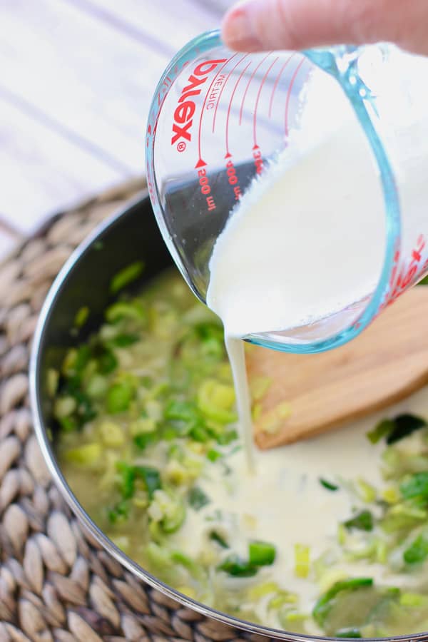 cream being poured over salted leeks