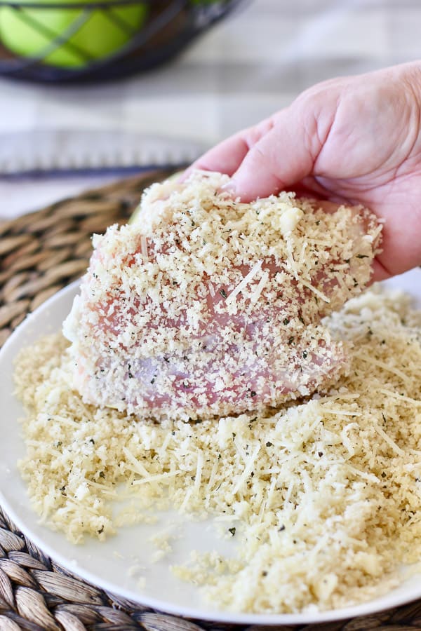 fresh chicken being coated with panko crumb mixture