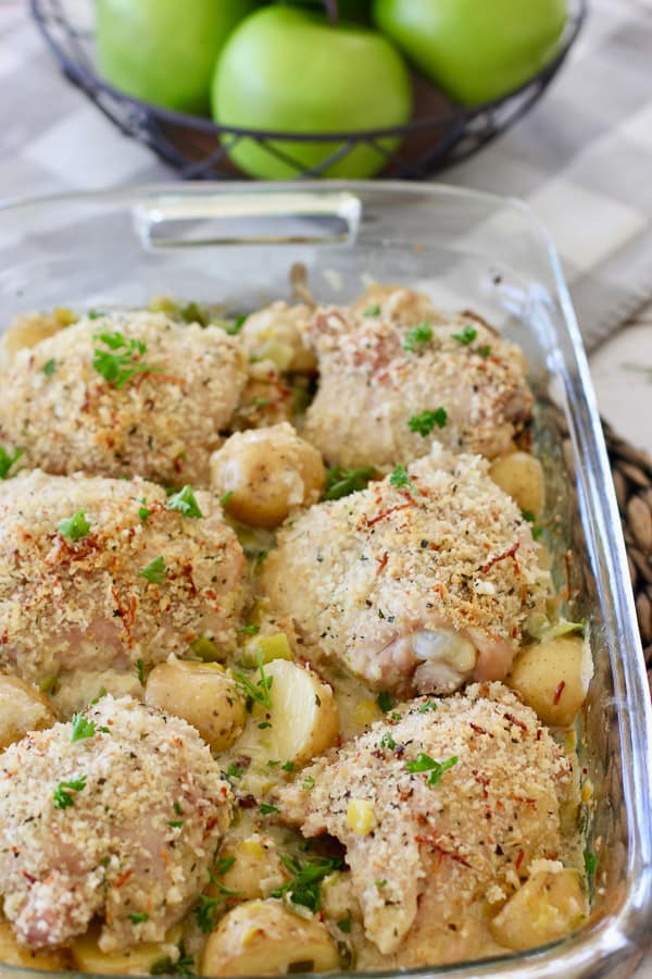 crispy chicken thighs on top of potatoes with creamy leek sauce