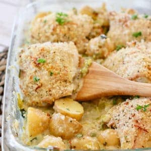 Crispy chicken thighs in a baking dish with potatoes and cream sauce