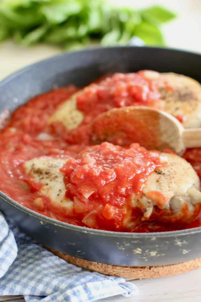 spoon tomato sauce over chicken breasts