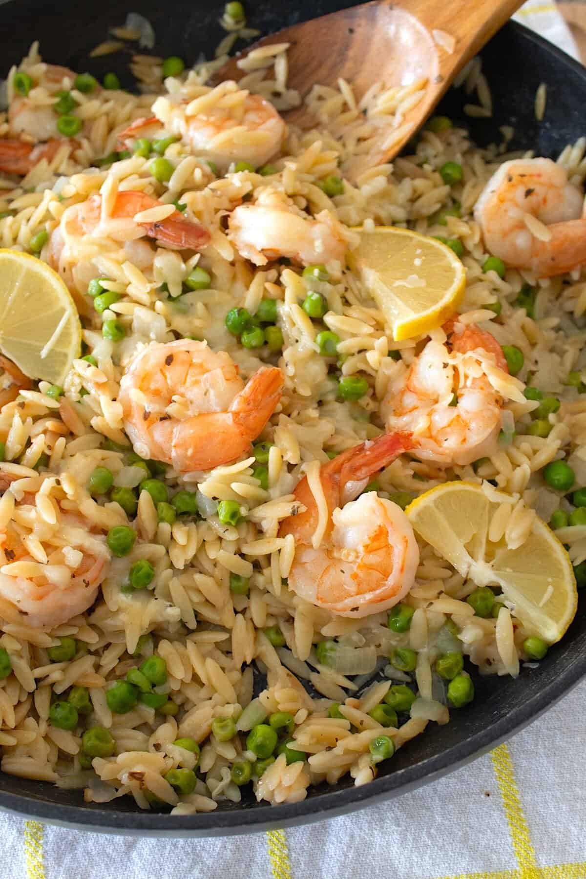 side view of shrimp orzo dinner in a black pan