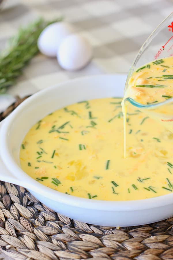 quiche being poured into pie plate