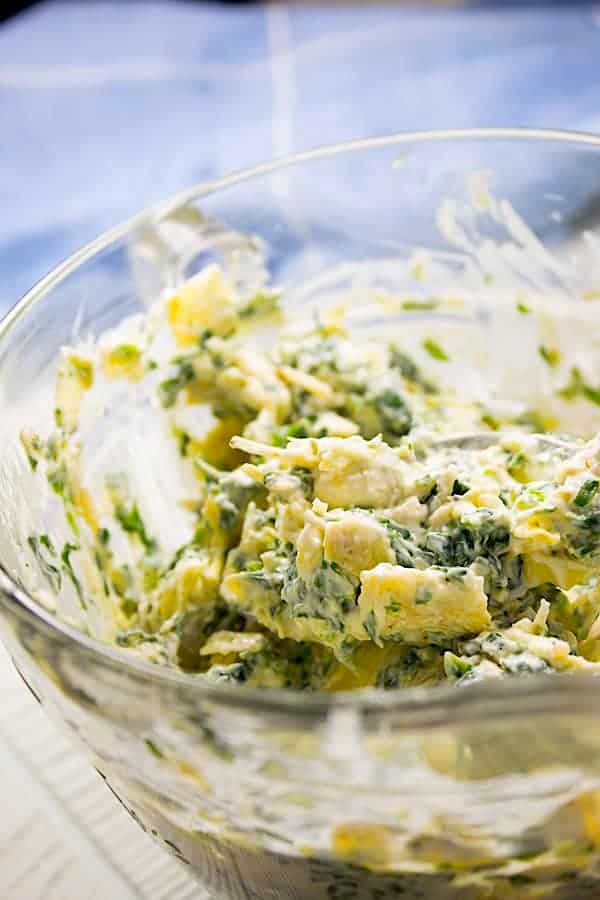 mixed spinach artichoke stuffing in clear bowl