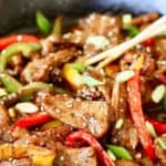 mongolian beef with peppers in skillet with chopsticks