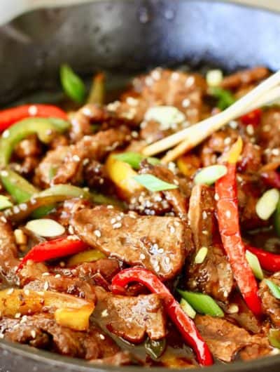 mongolian beef with peppers in skillet with chopsticks