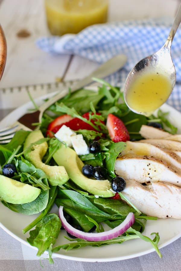 grilled chicken with strawberry spinach salad on a white plate