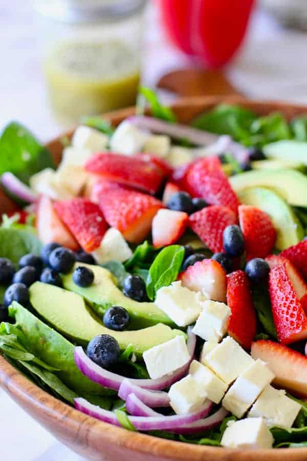 strawberry salad ingredients in a large wooden bowl