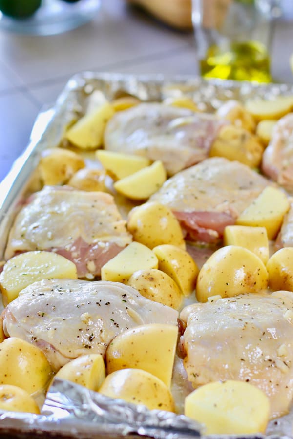 roasted chicken thighs and potatoes ready to go in the oven