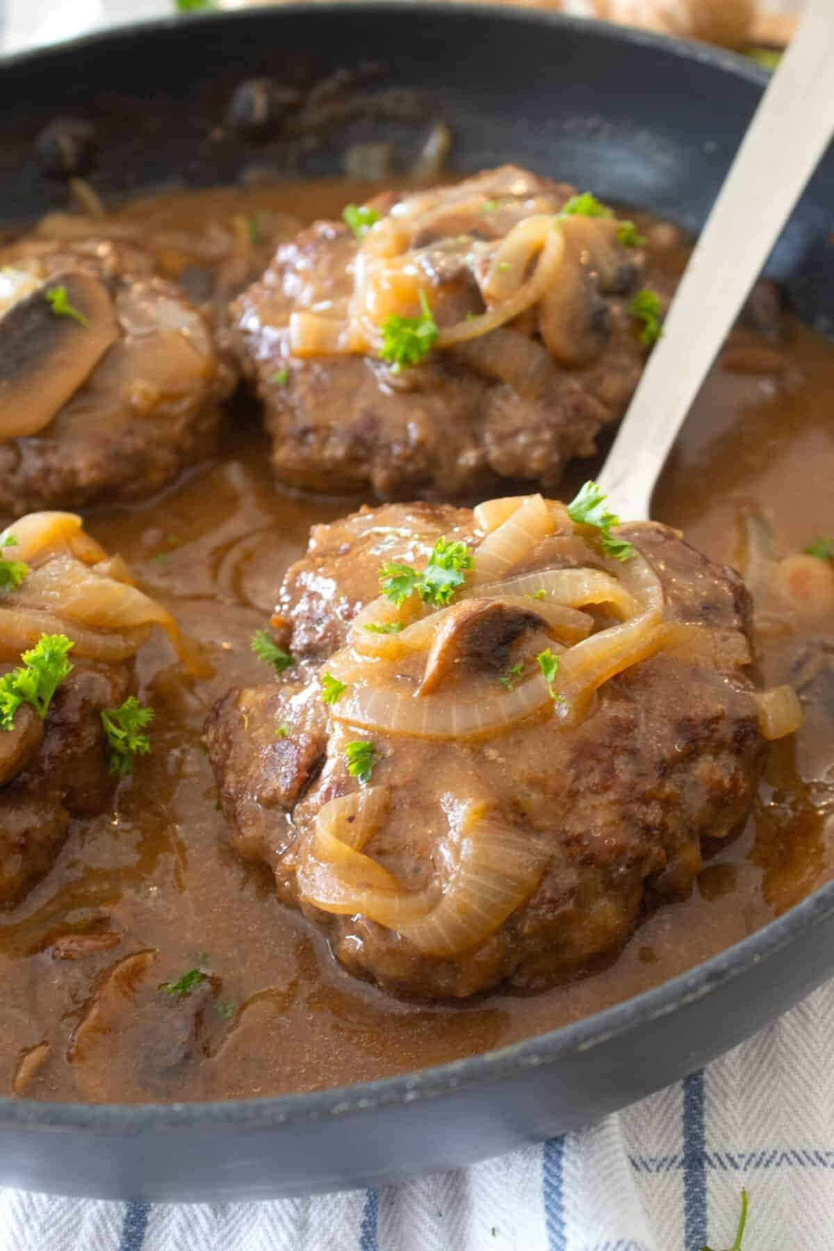 close up of salisbury steak in a pan