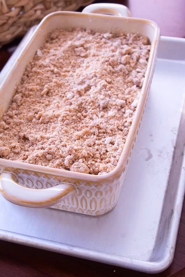 pumpkin loaf cake in loaf pan atop a sheet pan prepared to go in oven for baking