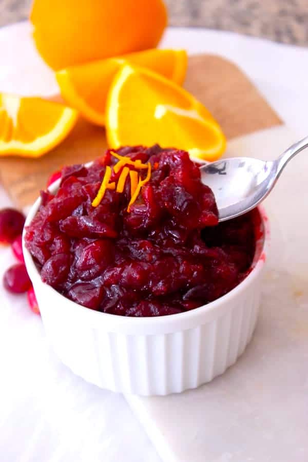 orange cranberry sauce with spoon in white bowl 