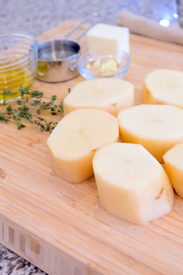 peeled cylindrical potatoes on a cutting board