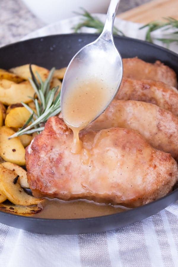 Cinnamon Crusted Pork Chops in a Black Pan with Sautéed Apples and Cider Glaze