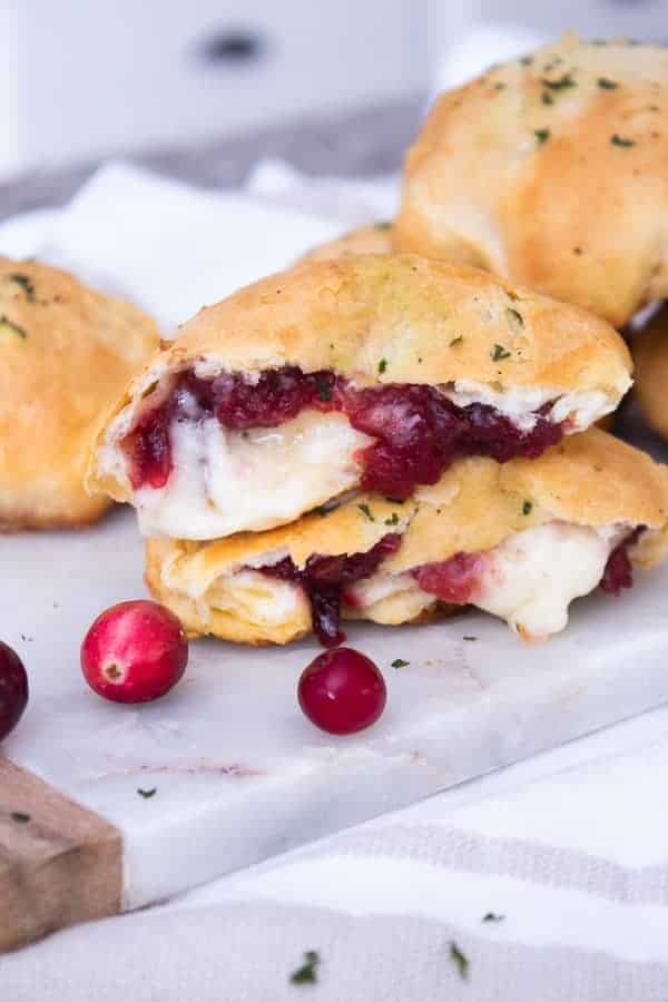 2 brie cranberry stuffed biscuits in half with gooey brie cheese