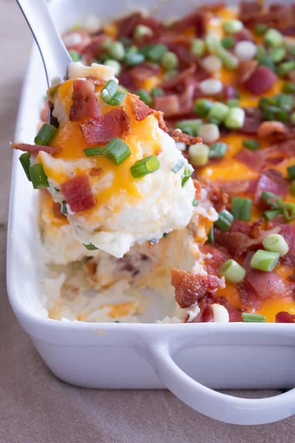 loaded mashed potato casserole in a white casserole dish