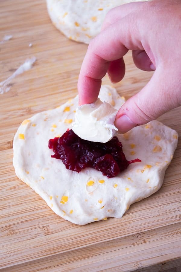 adding brie to cranberry brie stuffed biscuit