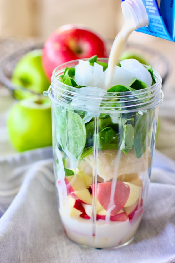 milk being added to green smoothie