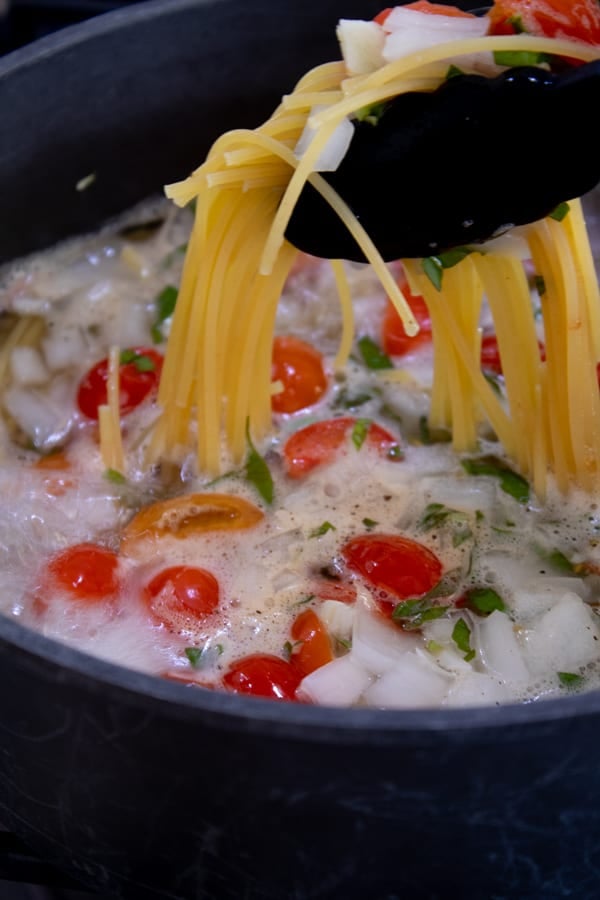 stirring one pot pasta with tongs