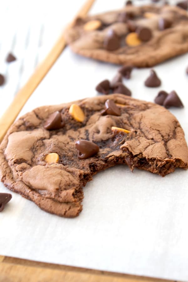 brownie cookie with bite out of it and chocolate chips in background