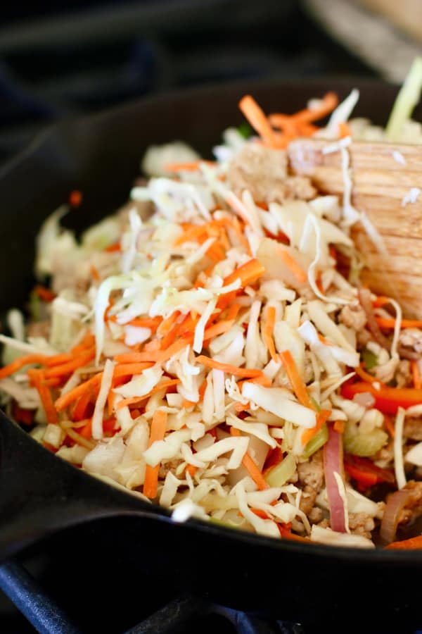 cabbage being added to egg roll bowl