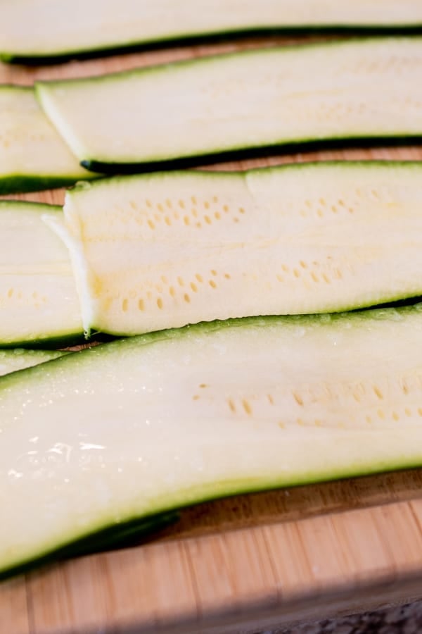 salted zucchini on a bamboo cutting board to remove moisture