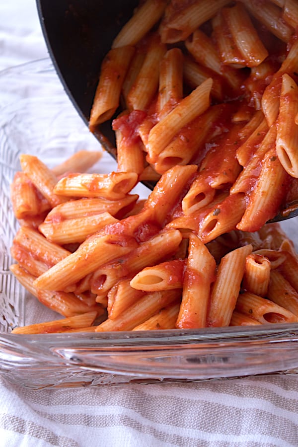 pouring penne in casserole dish