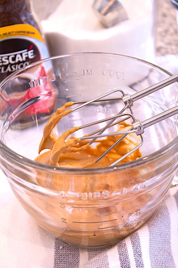 mixing ingredients for whipped coffee in clear bowl