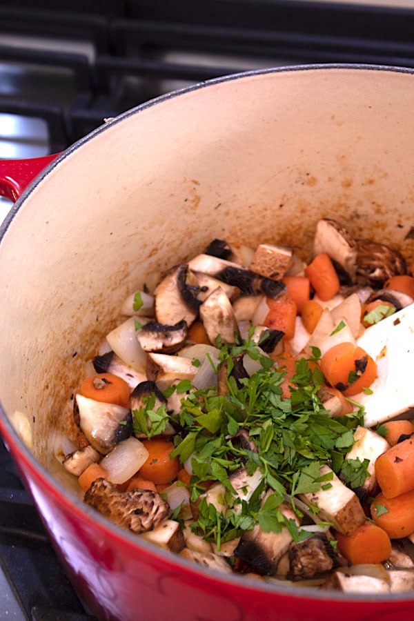 adding fresh parsley to stew