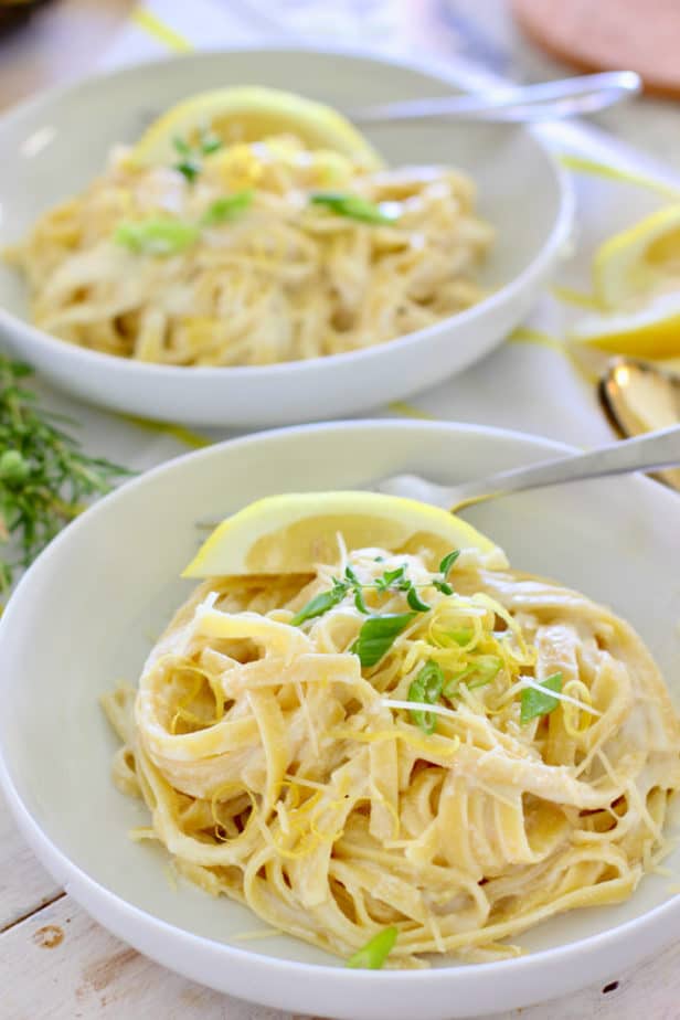 pasta and ricotta in a white bowl with lemon slices