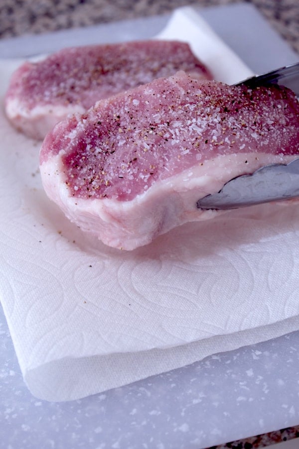 raw pork chop crusted with salt and pepper