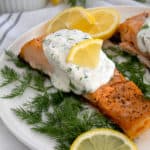 salmon and dill sauce on platter with dill and lemon garnish