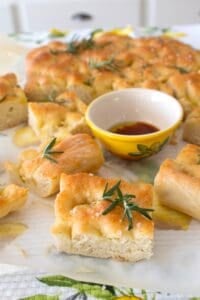 close up of focaccia bread with a small yellow dish full of oil and balsamic