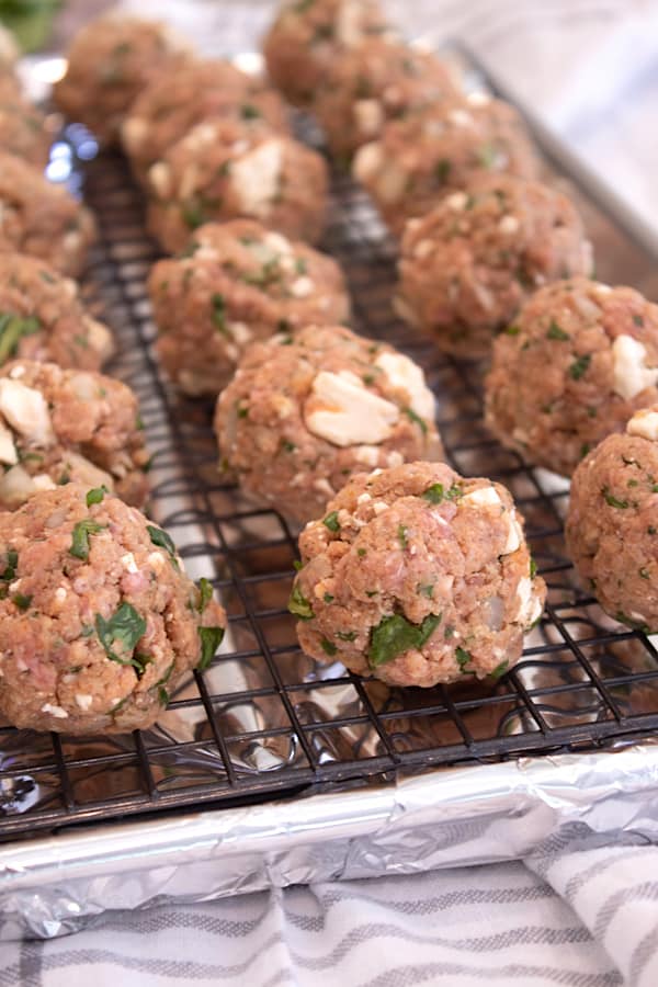 meatballs on cooking tray lined with foil and cooling rack to catch drippings