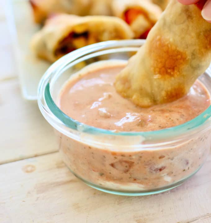 egg roll dipped into salsa sauce