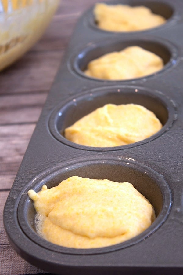 adding corn muffin batter to muffin tin with no liners