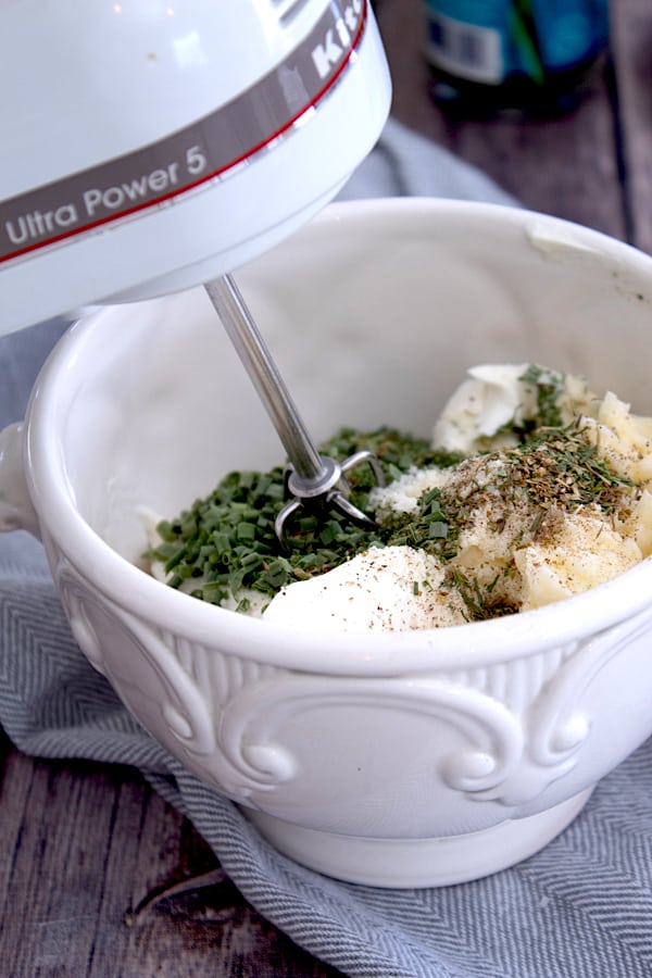 mixing Boursin cheese ingredients in bowl with hand mixer