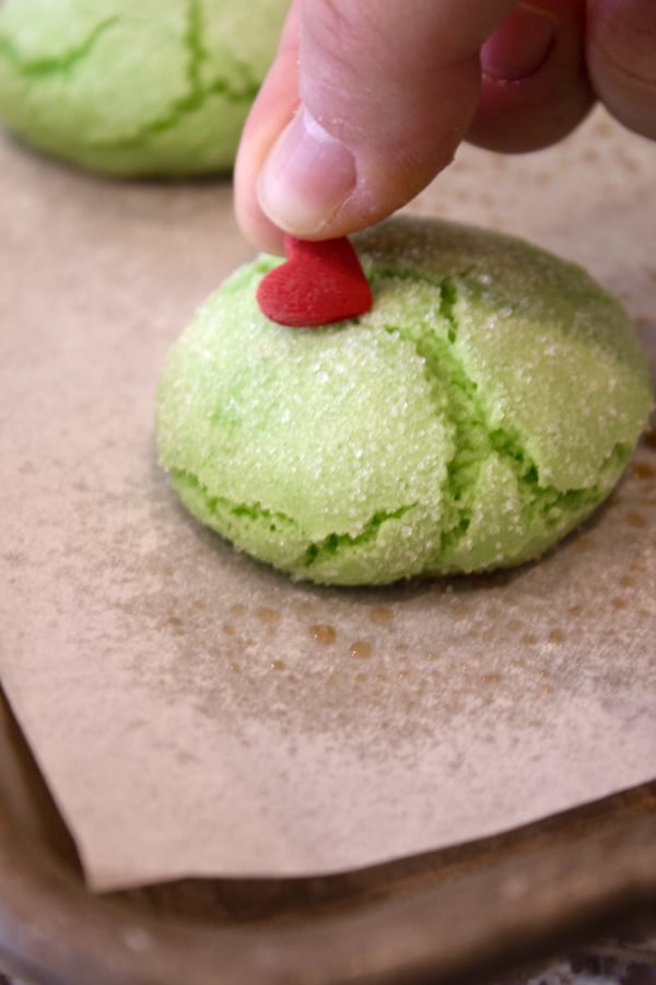 adding a red heart to a green grinch cookie