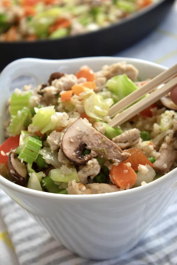 cauliflower rice in a bowl with chopsticks